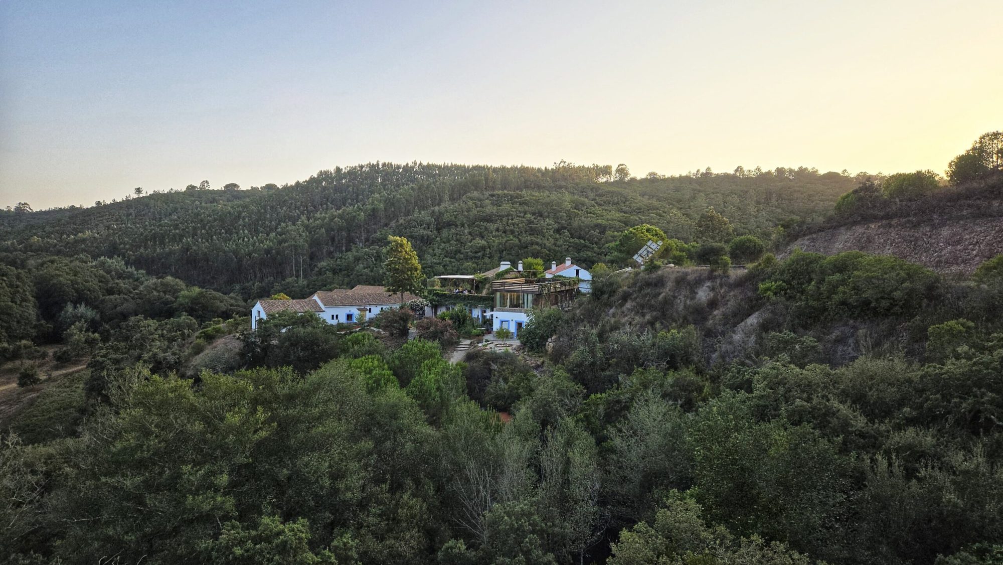 Le lieu de retraite, maisons blanches au milieu de collines boisées, au coucher du soleil